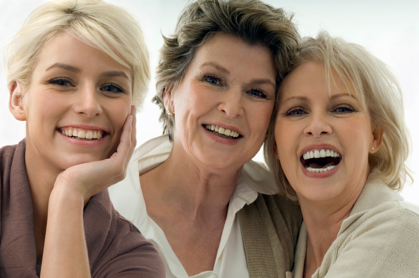 Group of women of three different ages, all smiling and looking vibrant.