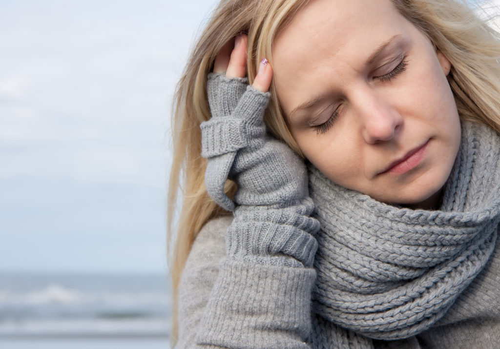 Woman with head on hand feeling tired