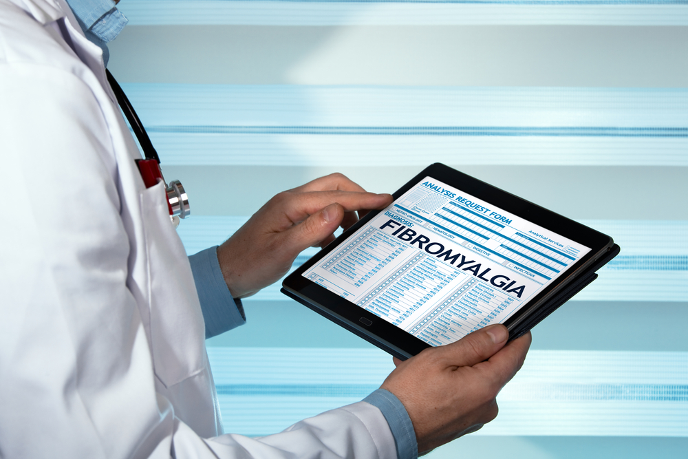 doctor looking at a fibromyalgia page on a tablet