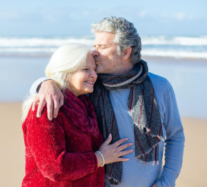 man and woman walking on beach