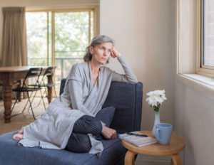 woman in living room looking out the window