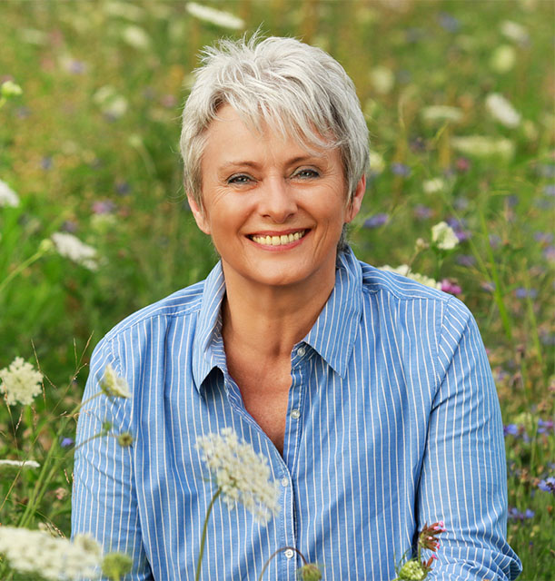 menopausal woman in a field, smiling
