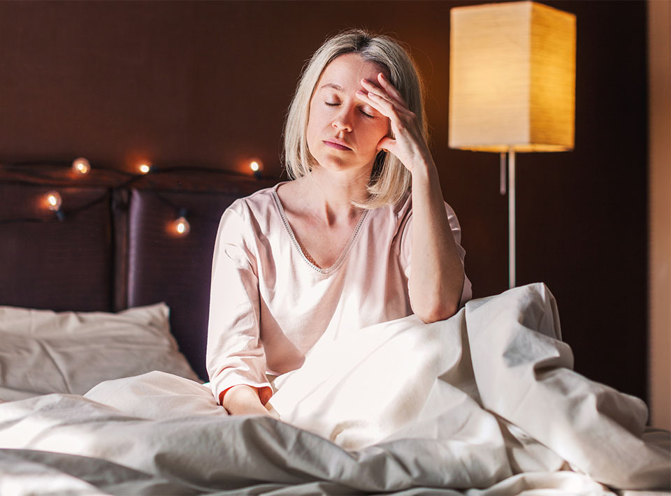 Woman with sleep problems sitting up in bed