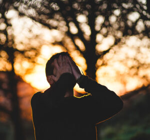 stressed man witih hands over face