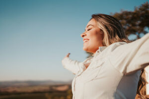 woman raising arms in the air with a feeling of relief