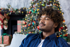 man doing deep breathing in front of Christmas tree
