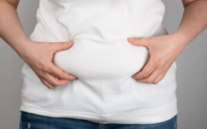 menopausal woman holding fat belly.