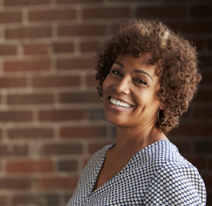 Happy black woman against a brick wall